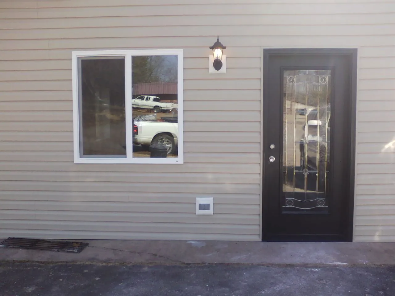 New siding, window and entry door on the side of an addition in Mathews